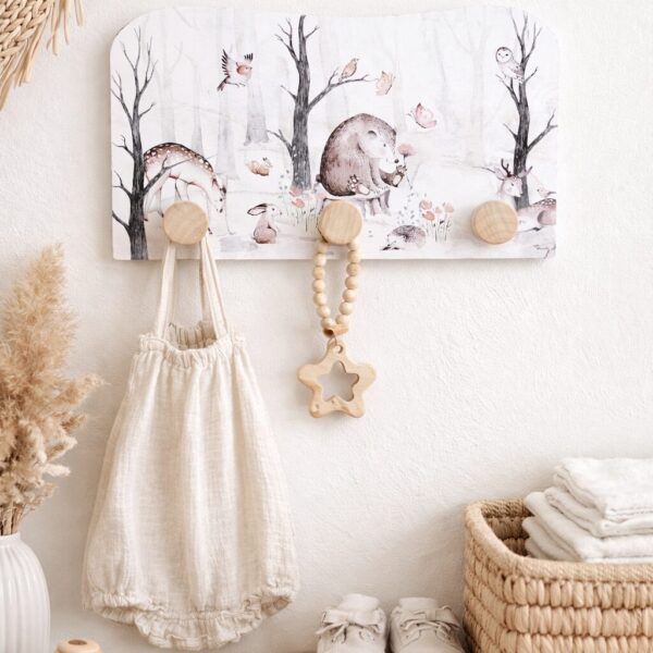 Wandkapstok met bosdieren illustratie in babykamer met natuurlijke decoratie en houten accessoires