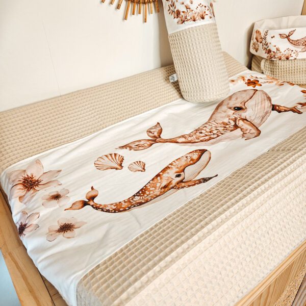 Babykamer aankleedkussen met bruine otter- en bloemenprint op beige wafeldoek met rotan wanddecoratie