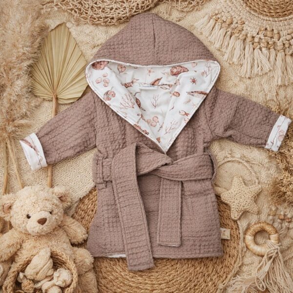 Taupe wafelstof kinderbadjas met capuchon en oceaanprint voering op rieten ondergrond met knuffel en decoratie