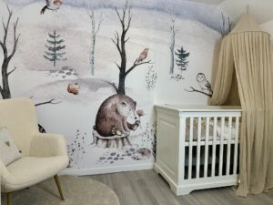 Babykamer met wit ledikant en behang van winterbos met bosdieren, egels, uil en vogels in aquarel