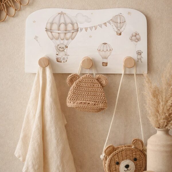 Kapstok babykamer met luchtballonmotief, houten haken, gebreide beren accessoires en natuurlijke tinten