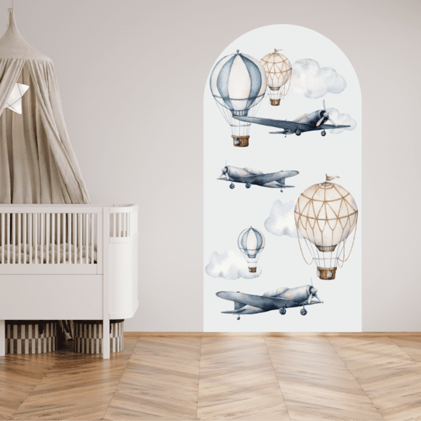 Babykamer met wit ledikant en wanddecoratie van luchtballonnen, vliegtuigen en wolken in aquarel