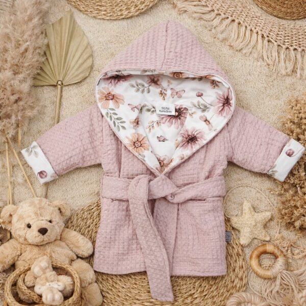 Roze baby badjas met capuchon en bloemenmotief op natuurlijke ondergrond met knuffelbeer en decoratie